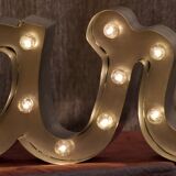 Enseigne lumineuse en lettrage aluminium formant le mot "bar"