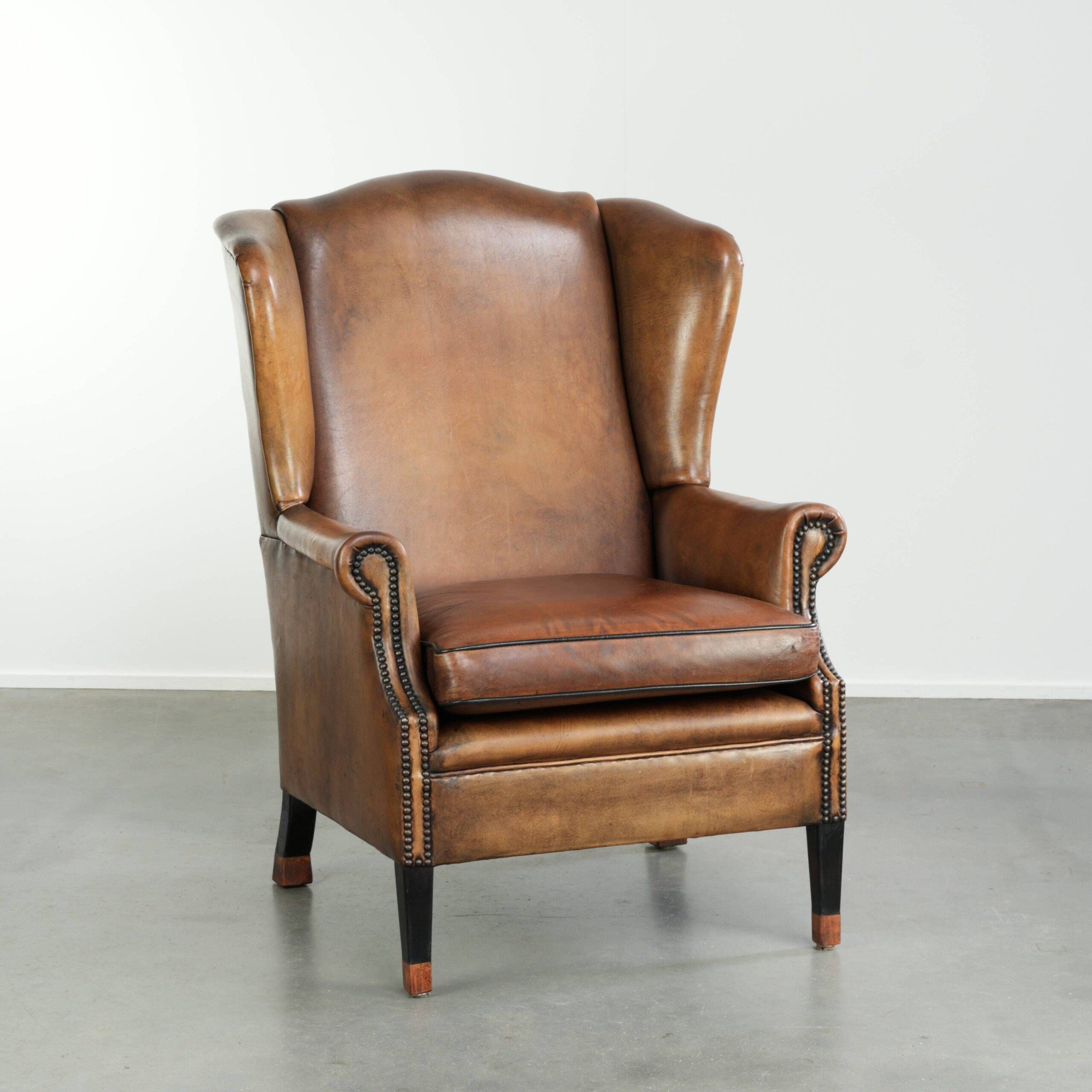 Sheepskin wingback armchair with patina finished with decorative nails