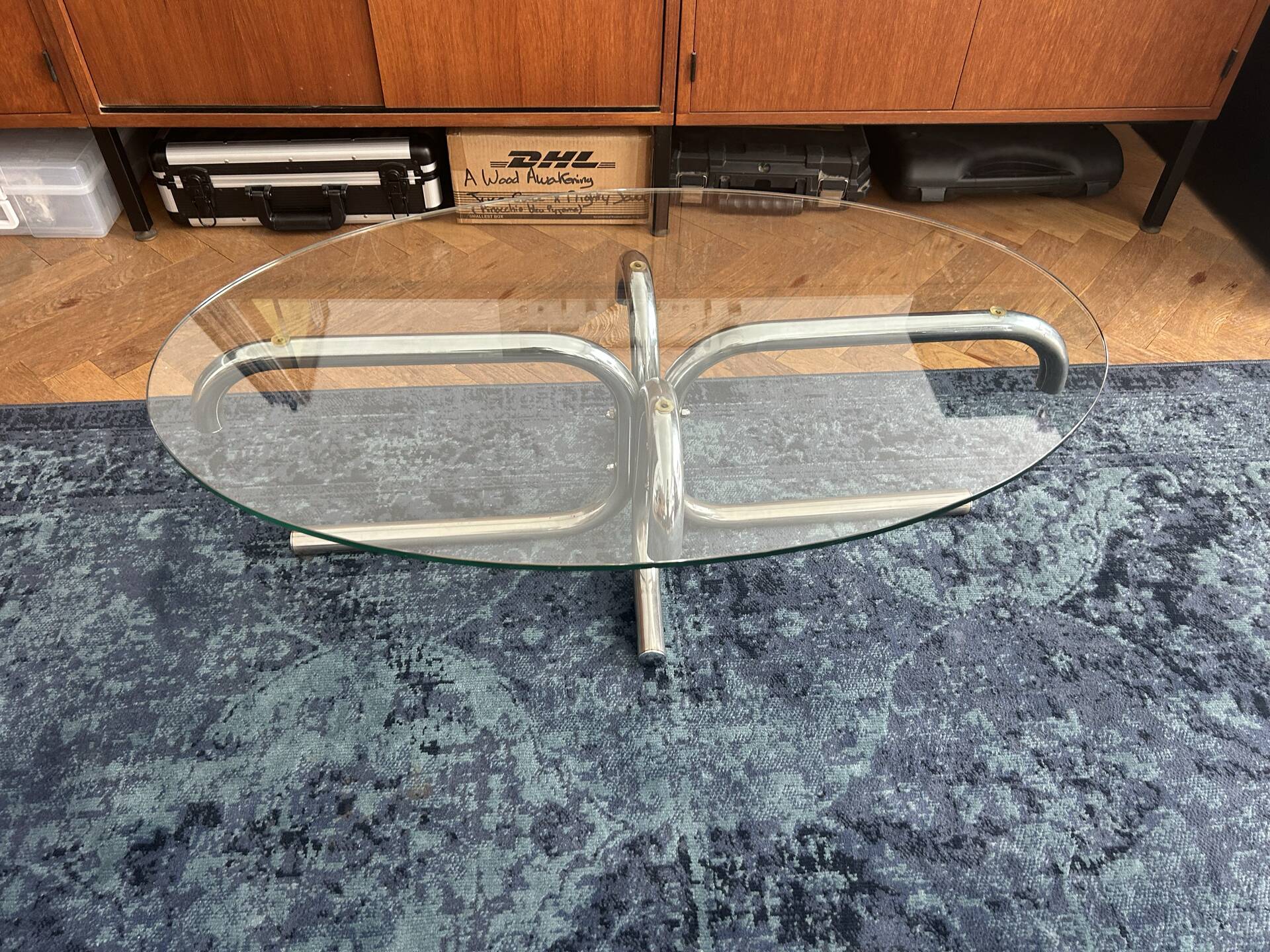 Oval glass coffee table with chrome legs, vintage 70s design.