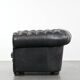 Ensemble composé d'un canapé chesterfield noir, d'un fauteuil et d'un pouf.