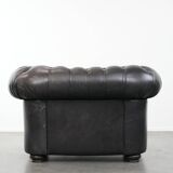 Comfortable black chesterfield armchair made of cowhide leather