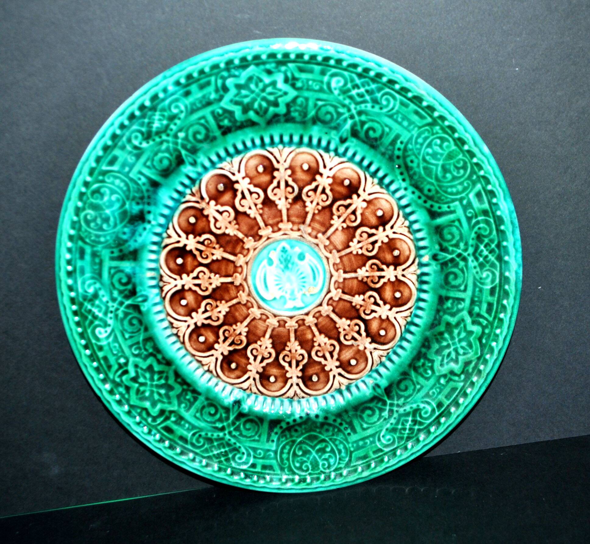 Antique plate in turquoise brown green slip with arabesque decoration