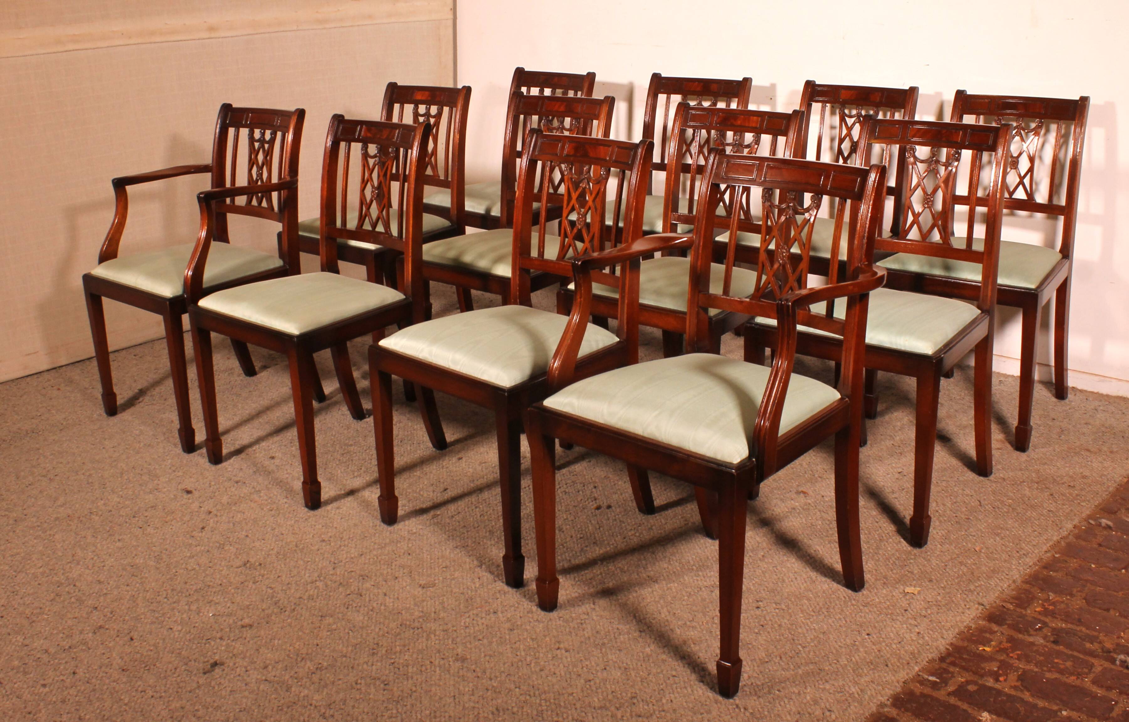 set of 10 chairs and two mahogany armchairs in Hepplewhite style