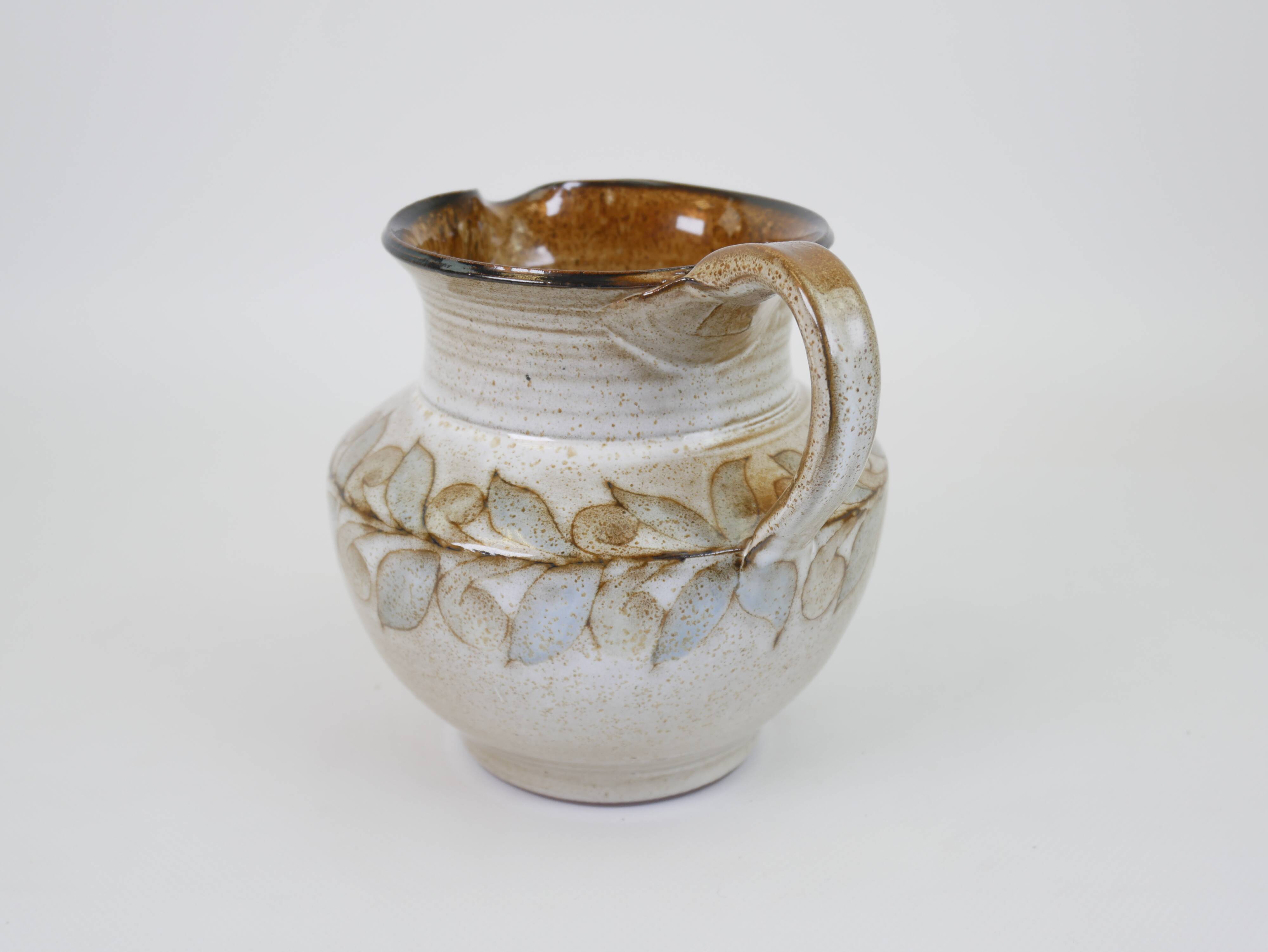 Glazed ceramic jug with plant decoration