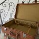 Antique suitcase with brown leather straps