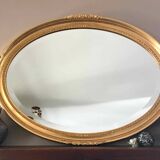 Beveled oval mirror with carved gilded wood frame