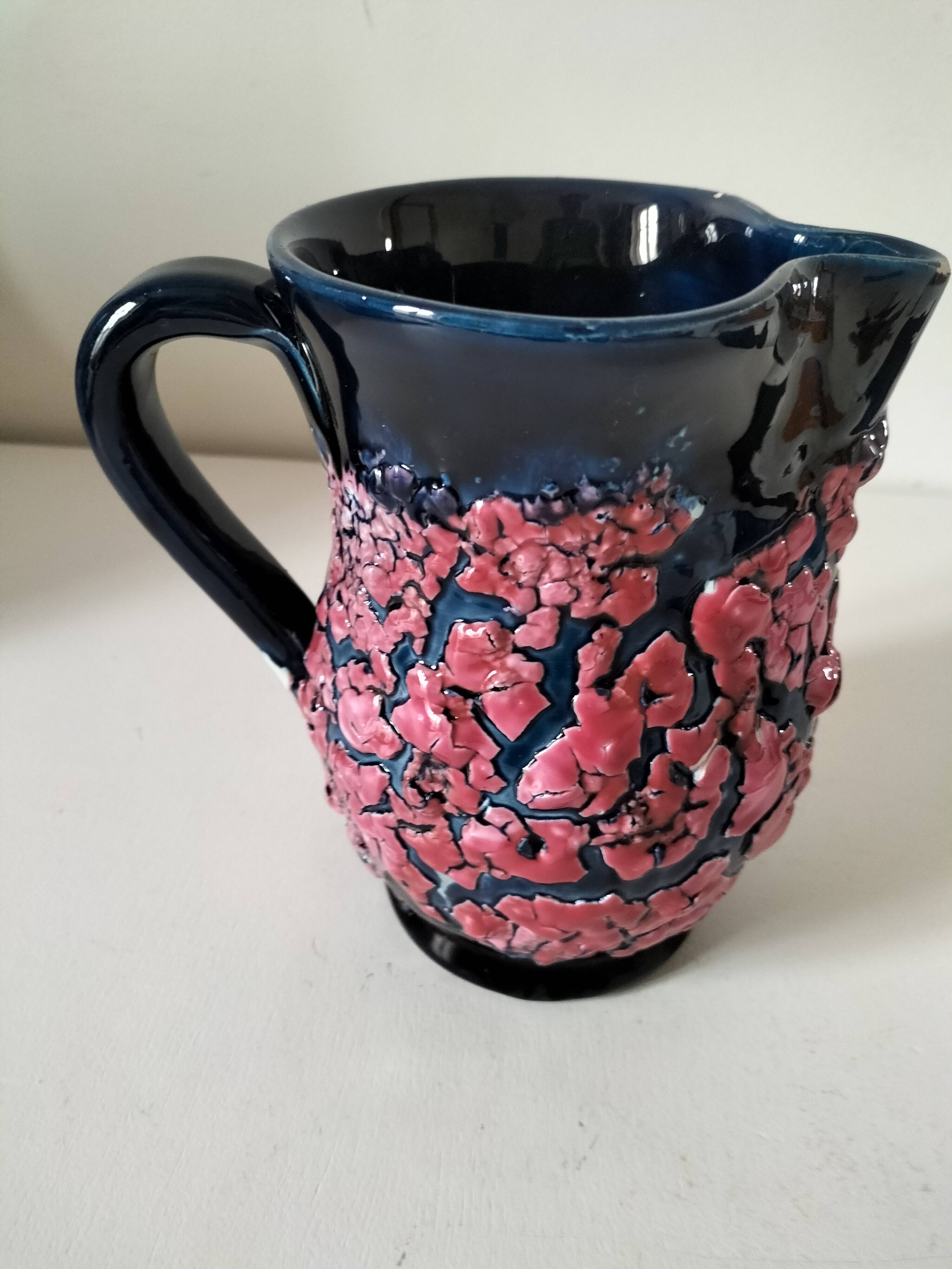 Vintage pitcher in midnight blue glazed ceramic with bright pink relief