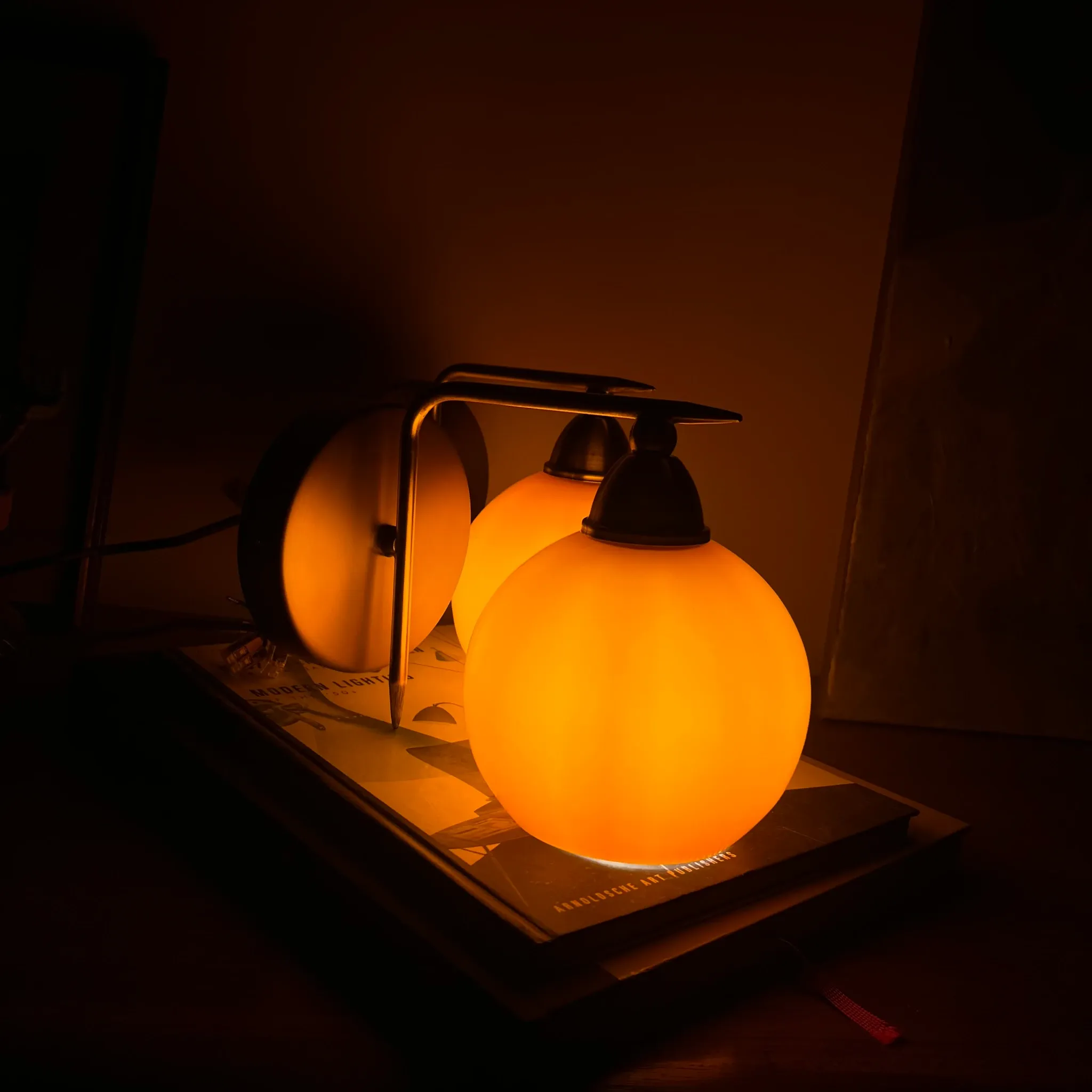 Pair of wall sconces with orange opaline glass globes and brass.