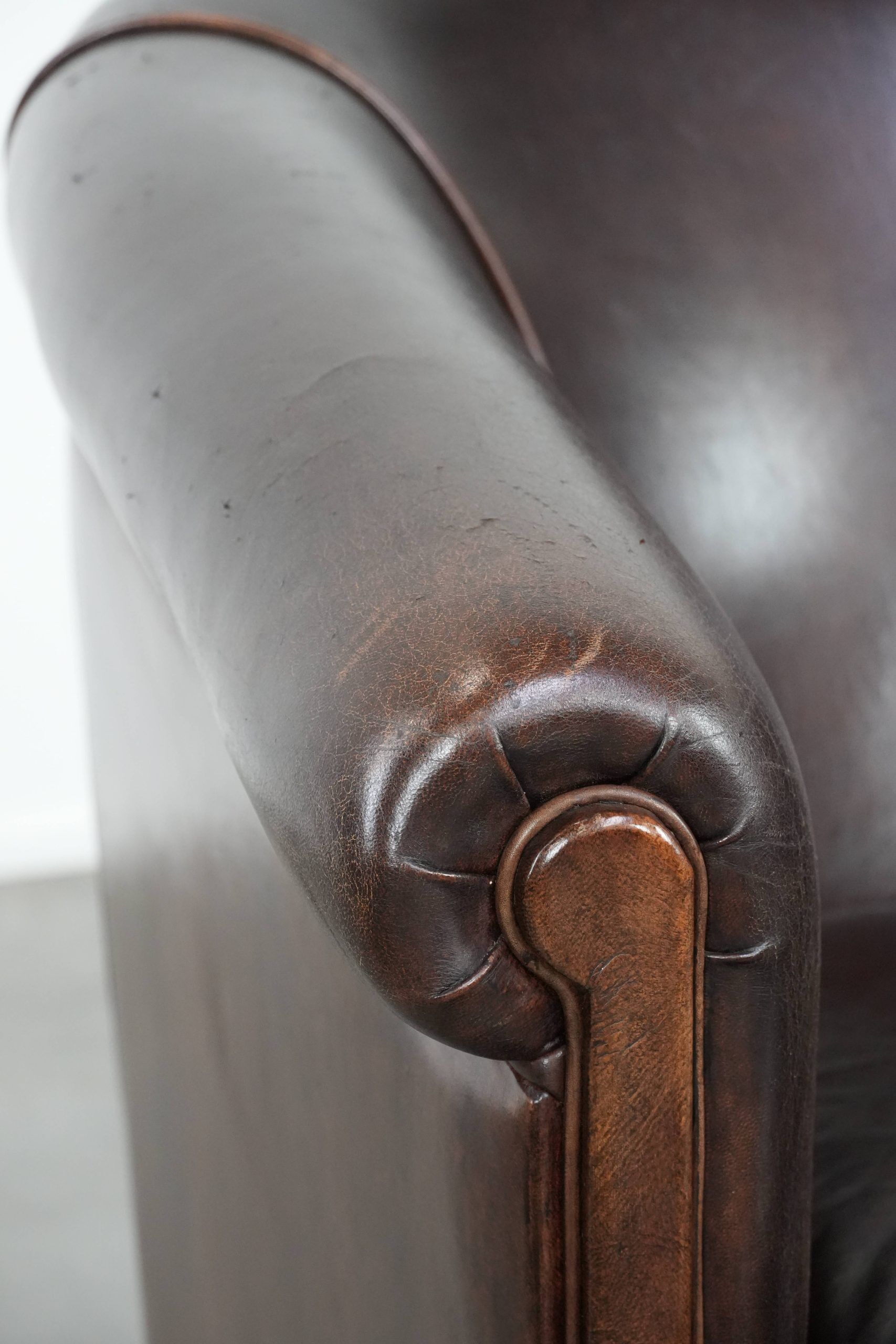 Dark brown vintage club armchair in English style made of sheepskin leather