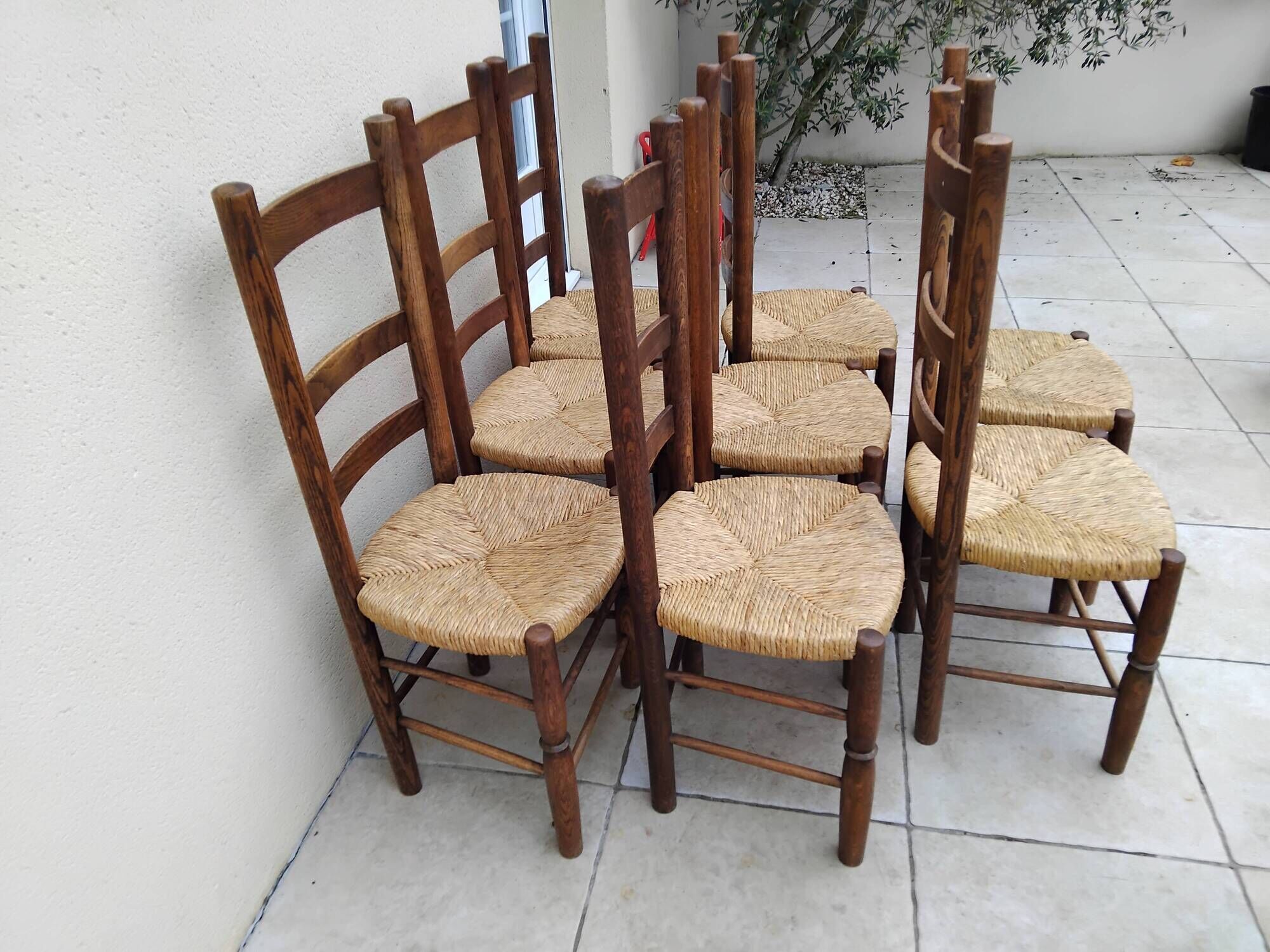 8 vintage straw chairs in the style of Charlotte Perriand.