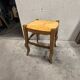 Rustic wooden stool with a straw seat.