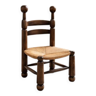 Low fireplace chair in the style of Charles Dudouyt – wood and straw seat.