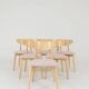 Set of 6 soft pink fabric dining chairs, Scandinavian design, natural wood.
