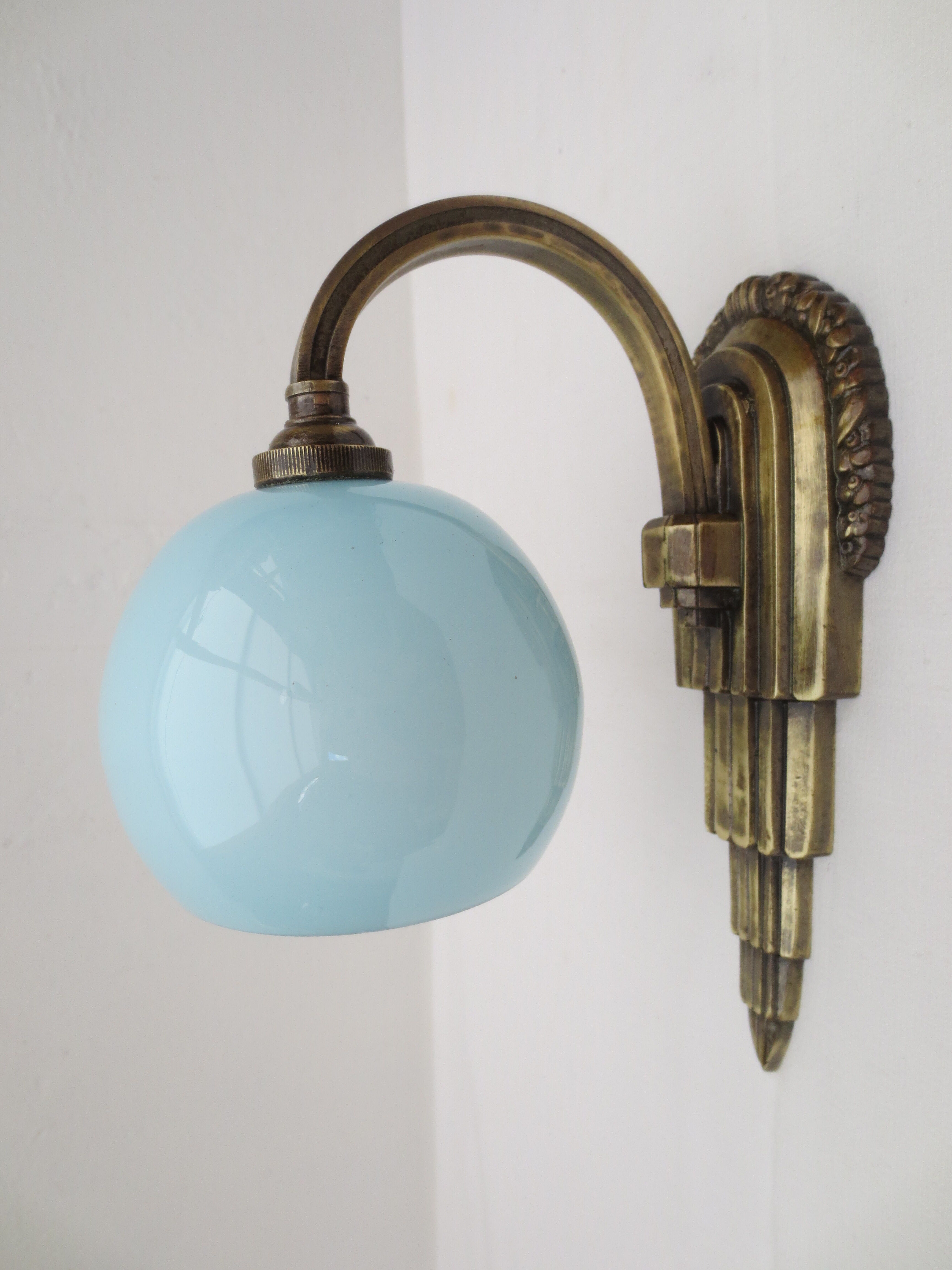 Art deco wall lamp in brass and soft blue opaline globe