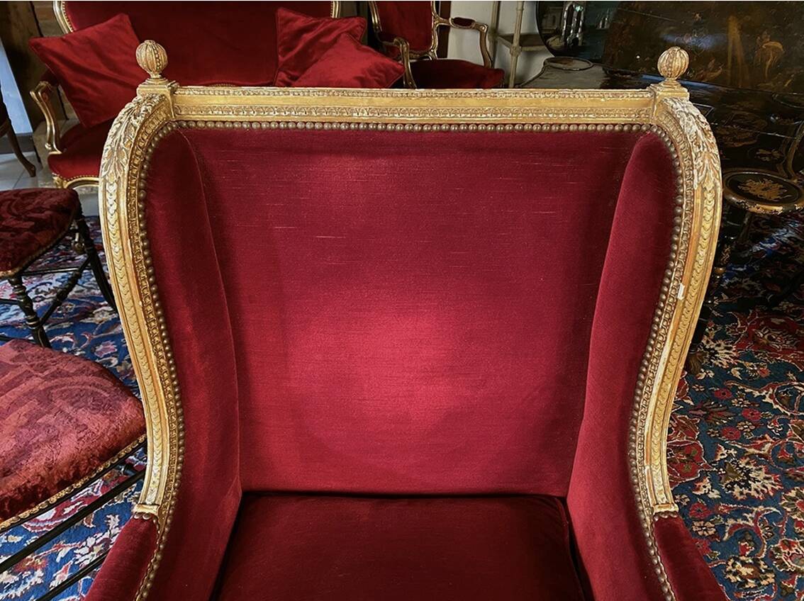 Golden wooden bergère in Louis XVI style upholstered in Bordeaux velvet.