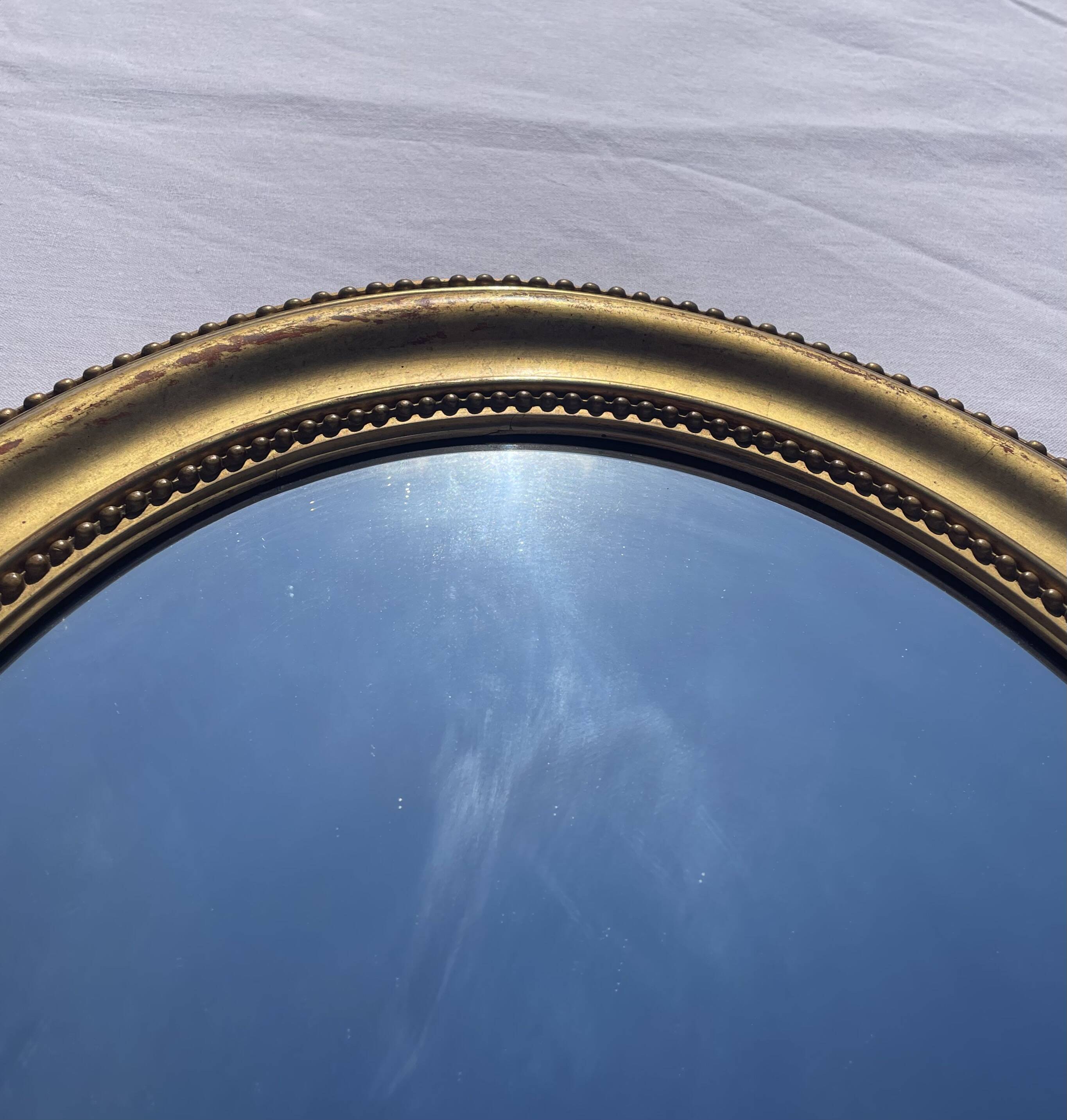 Duo de miroirs ovales et dorés en bois