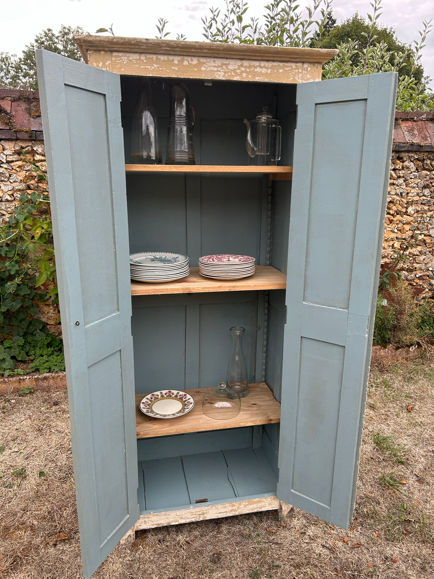 Small antique wardrobe with a faded white patina.