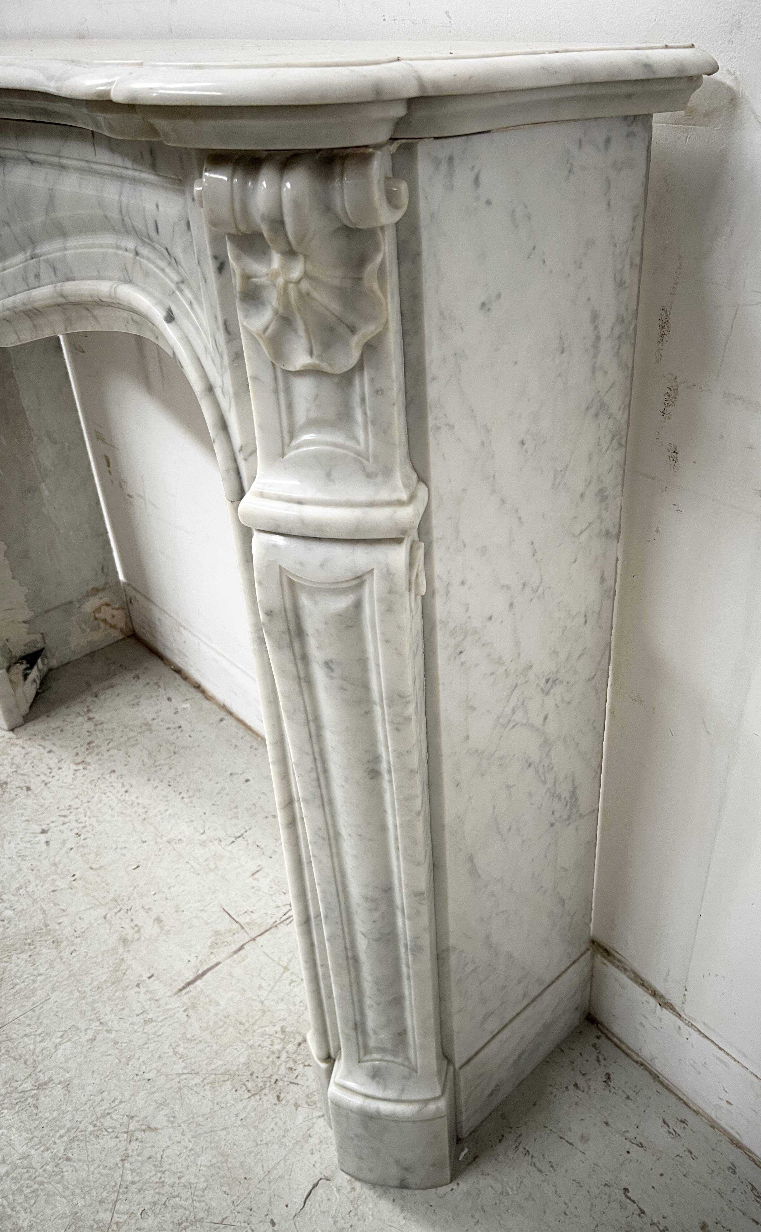 Louis XV style fireplace in veined white marble, 20th century.