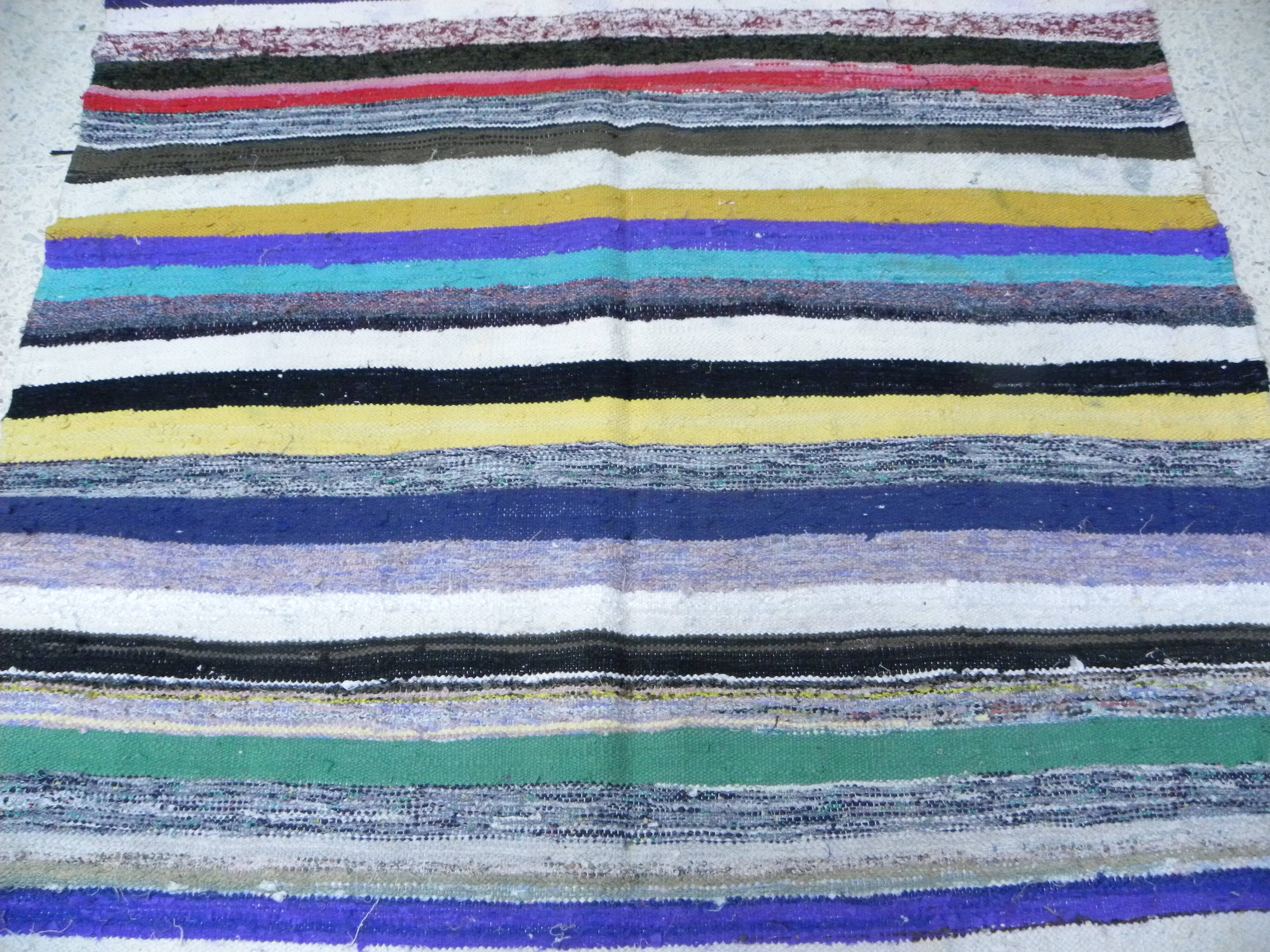 Vintage traditional nomadic kilim ethnic rug with multicoloured stripes.