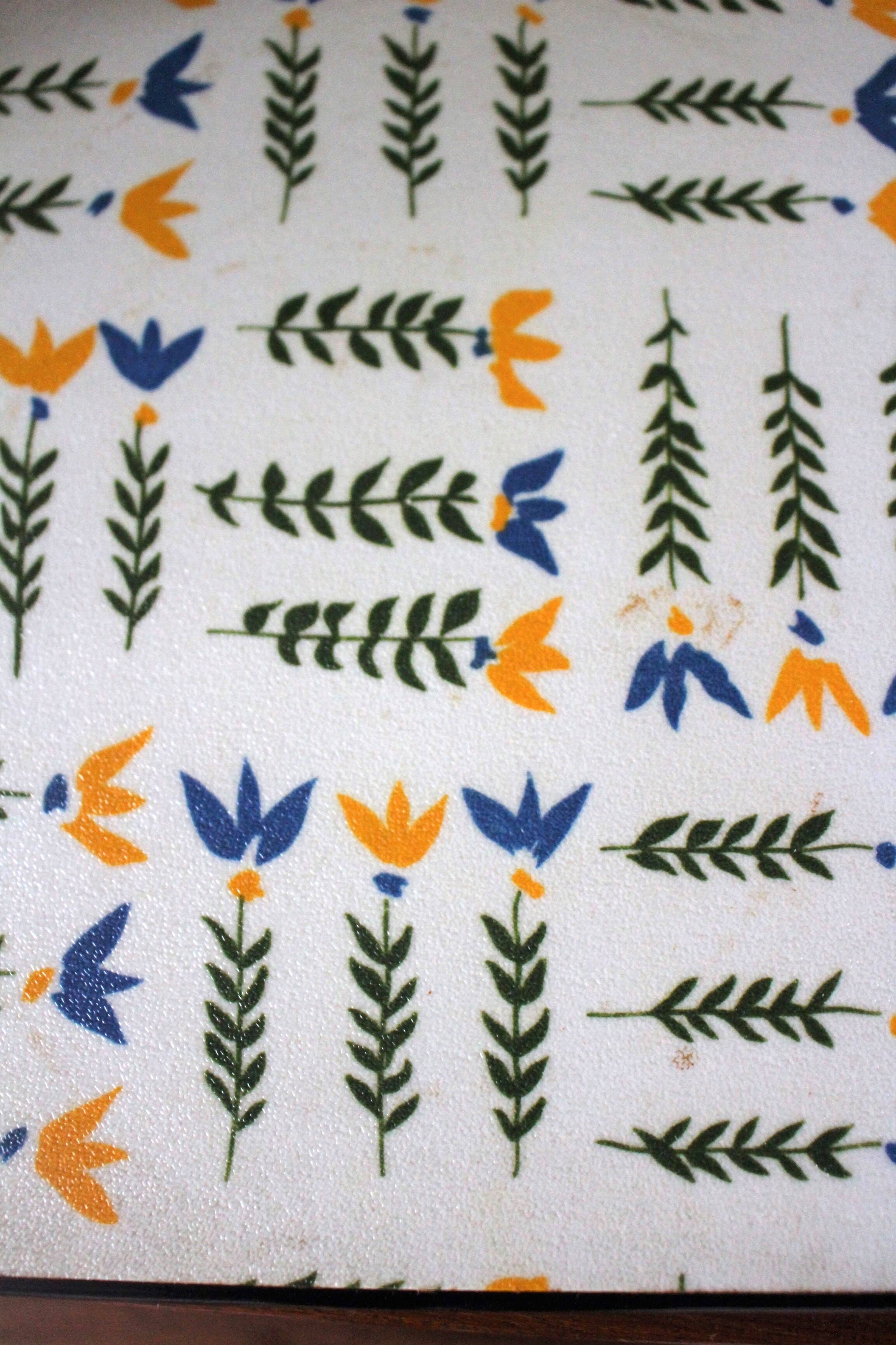 Vintage laminated wooden trivet with yellow, green, and blue flowers