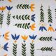 Vintage laminated wooden trivet with yellow, green, and blue flowers
