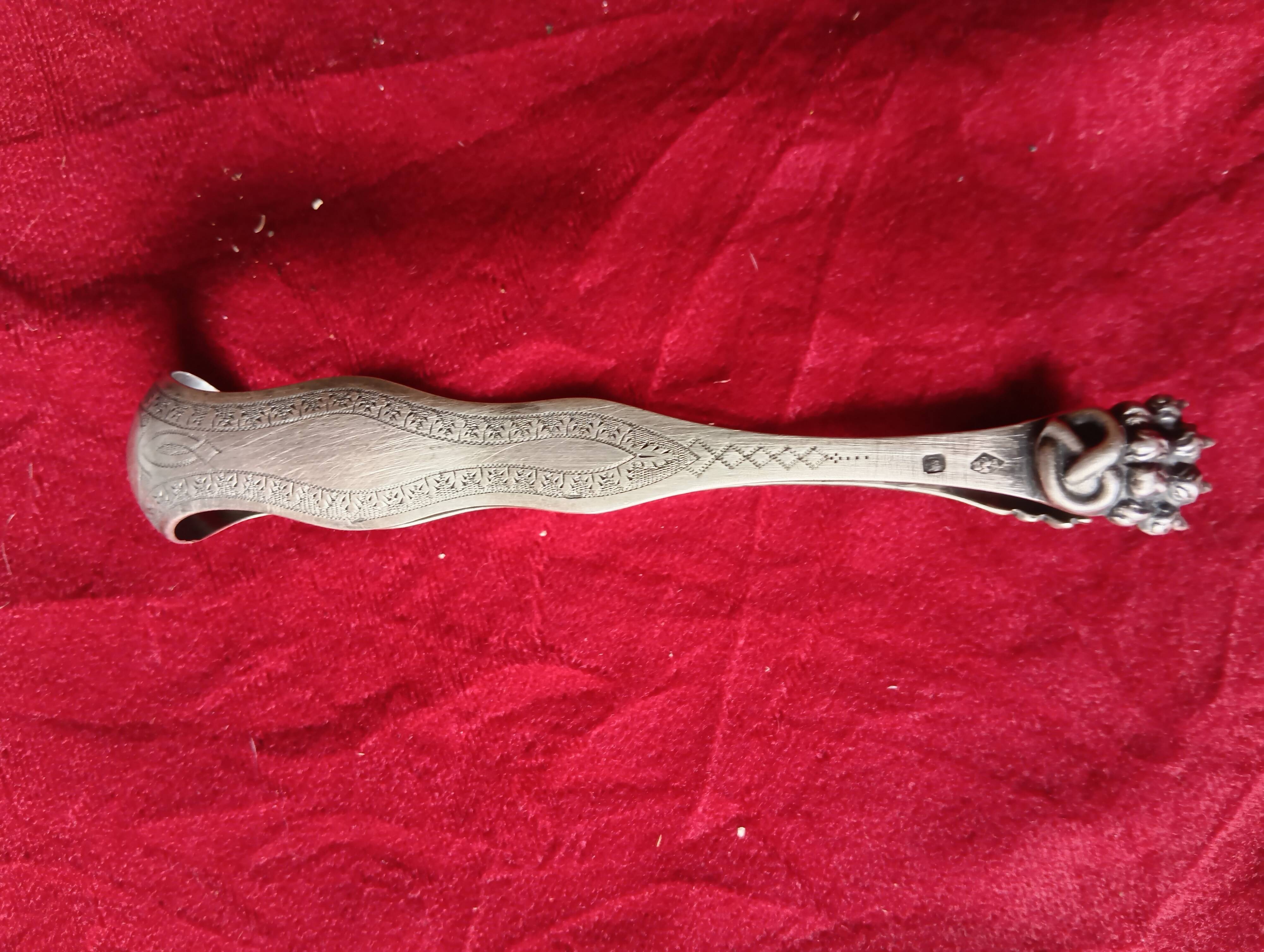 Silver sugar tongs with engraved decoration and lion claws.