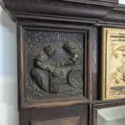 Renaissance-style mirror in wood and copper with a craftsmanship theme.