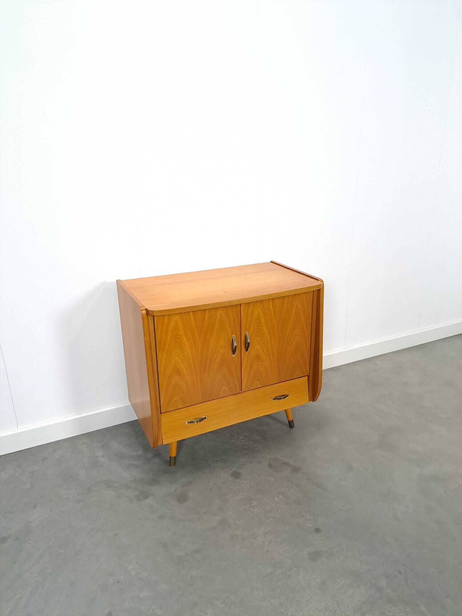 Meuble TV audio avec poignées en laiton et pieds inclinés.