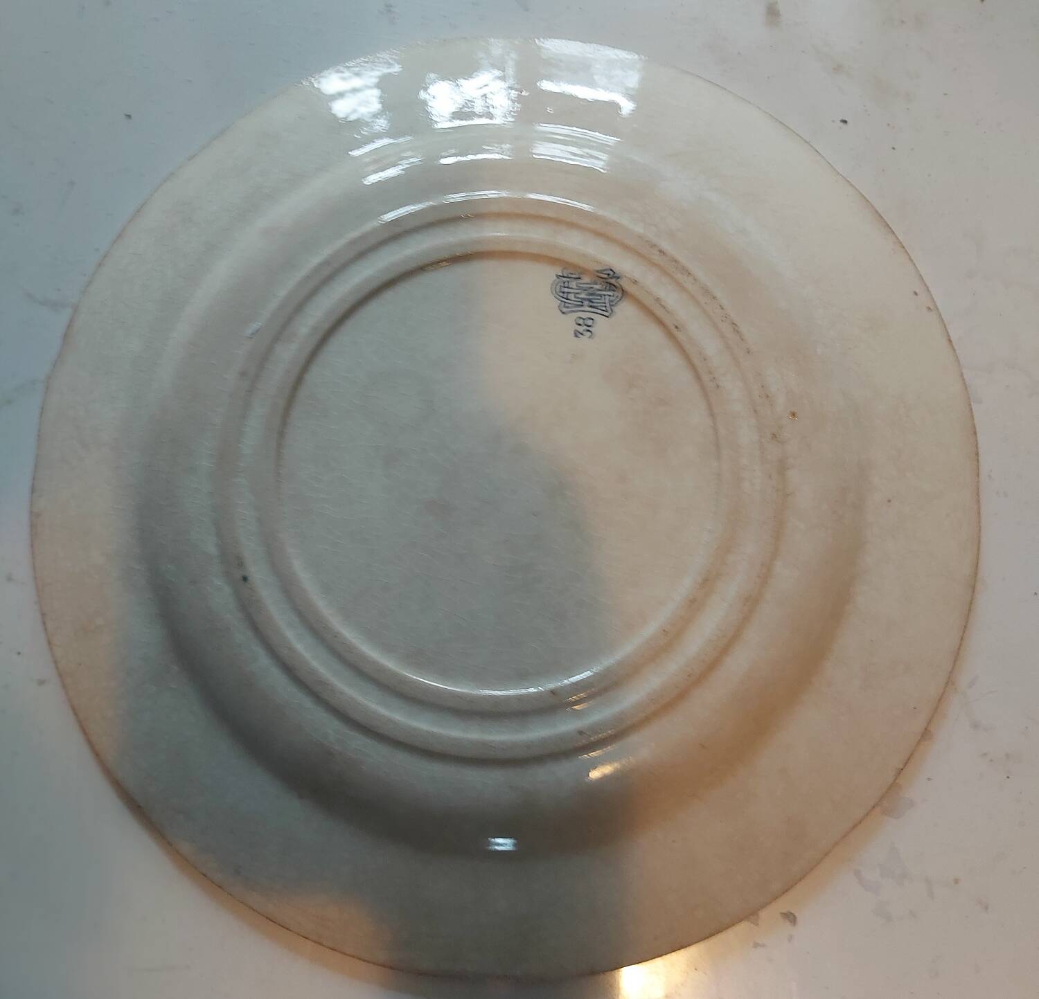 Two antique 19th-century plates, one flat and one deep, from Gien.