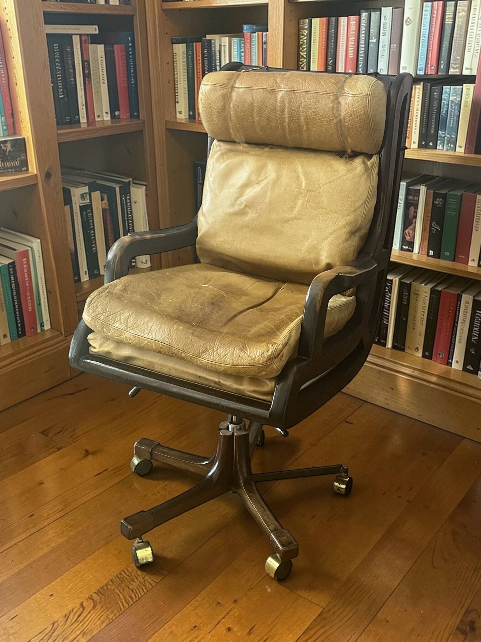 Vintage mahogany and havana leather office chair with wheels from around 1970.