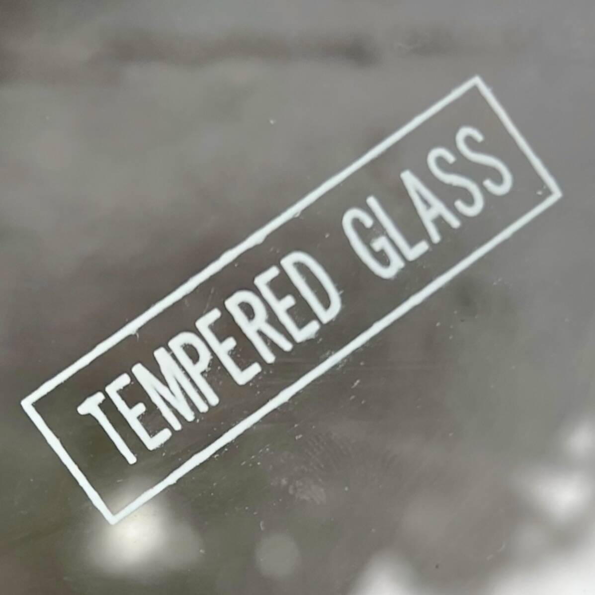 Modernist tripod side table in tempered glass and chrome metal.