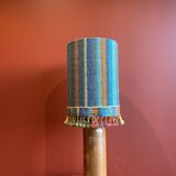 "Stoneware Bottle Lamp" with a multicoloured blue lampshade handwoven in India.