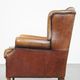 Cognac-colored sheep leather wingback chair finished with black piping