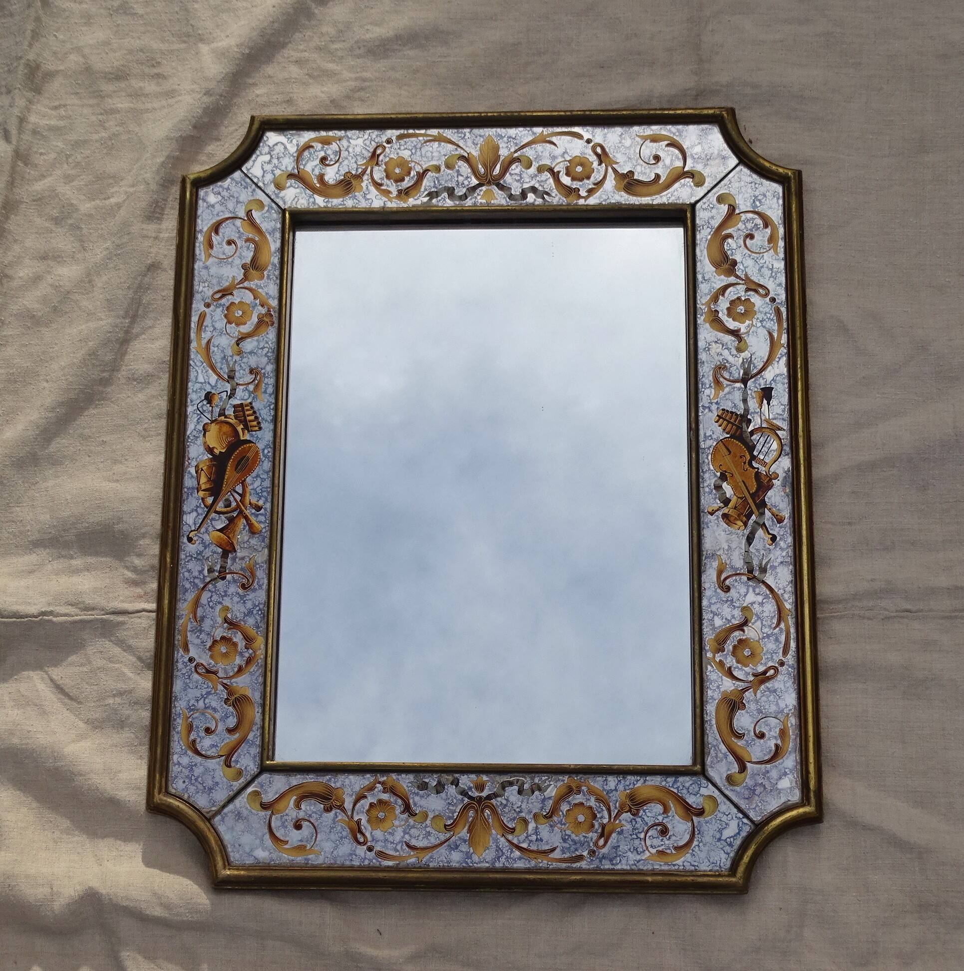50s Eglomisé glass mirror with musical instrument decor