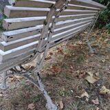Pair of antique wooden slatted benches with wrought iron legs.