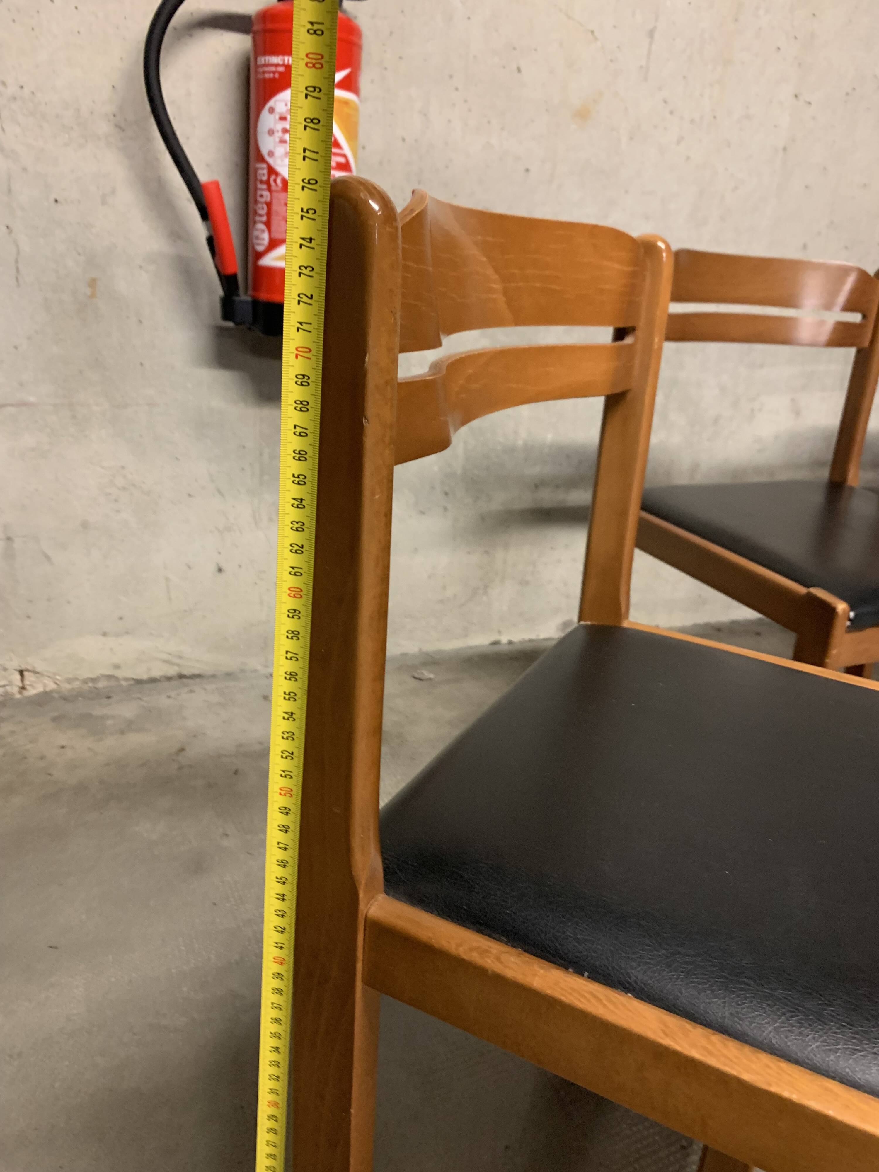 Set of four vintage chairs upholstered in retro design faux leather.