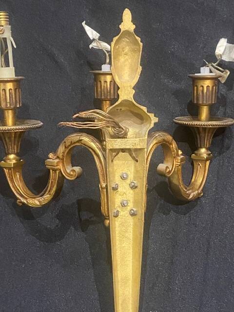 Pair of gilt bronze wall sconces with three lights in the Louis XVI style.