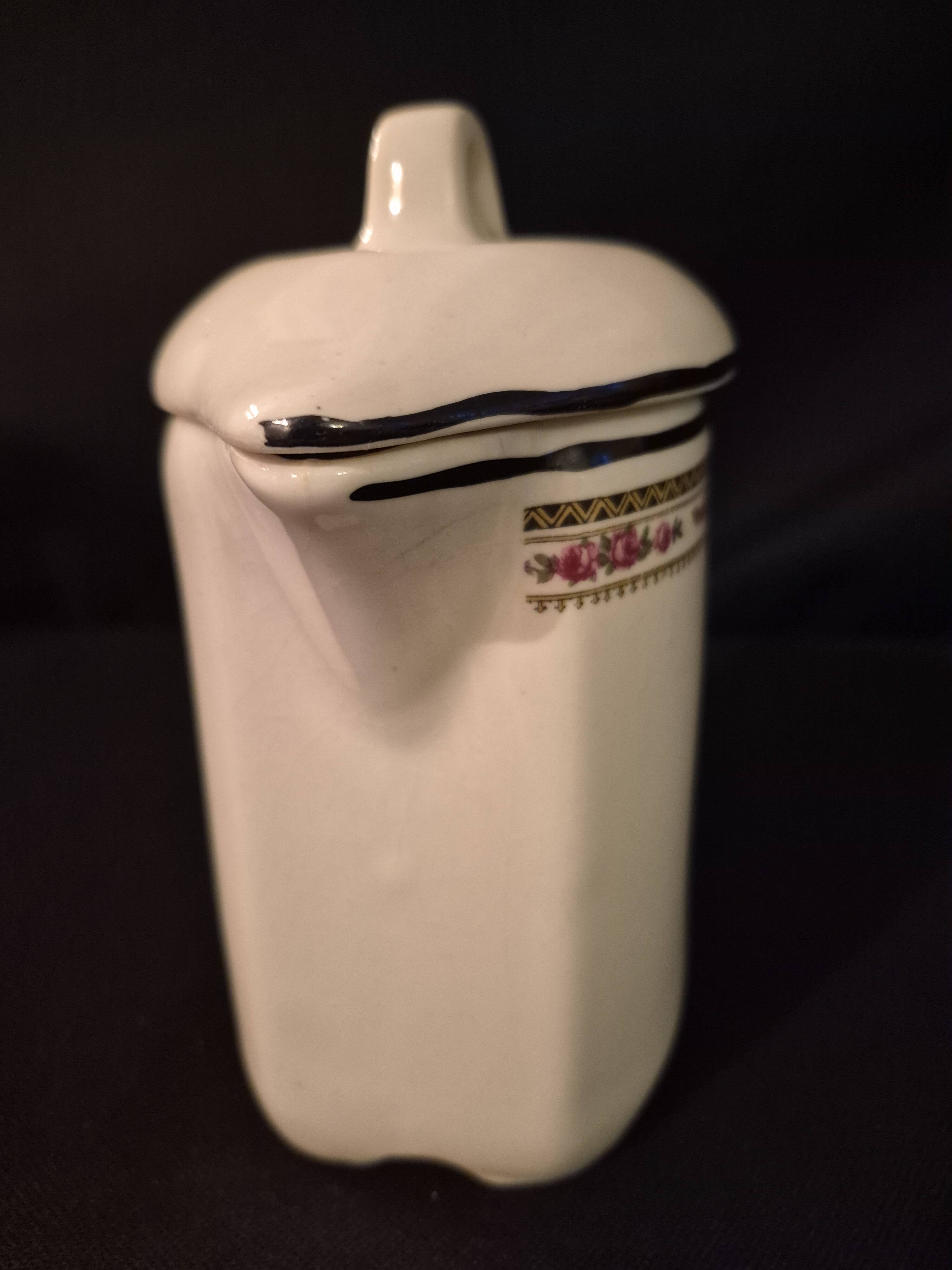 Old covered jug, vintage, geometric frieze with flowers and black trim.