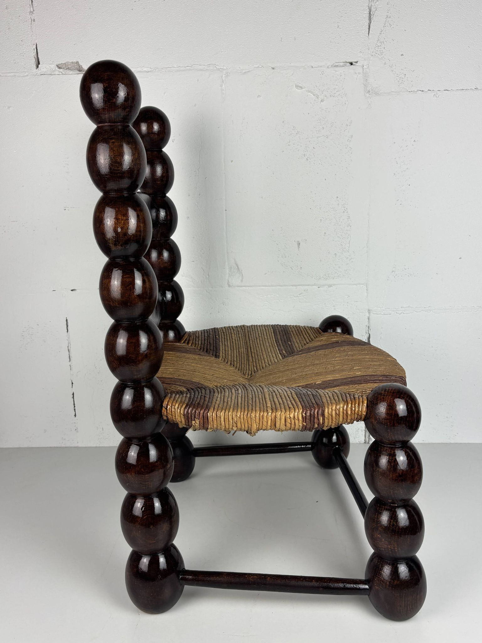 Brutalist wood turned bobbin low rush chair n the style of Charles Dudouyt