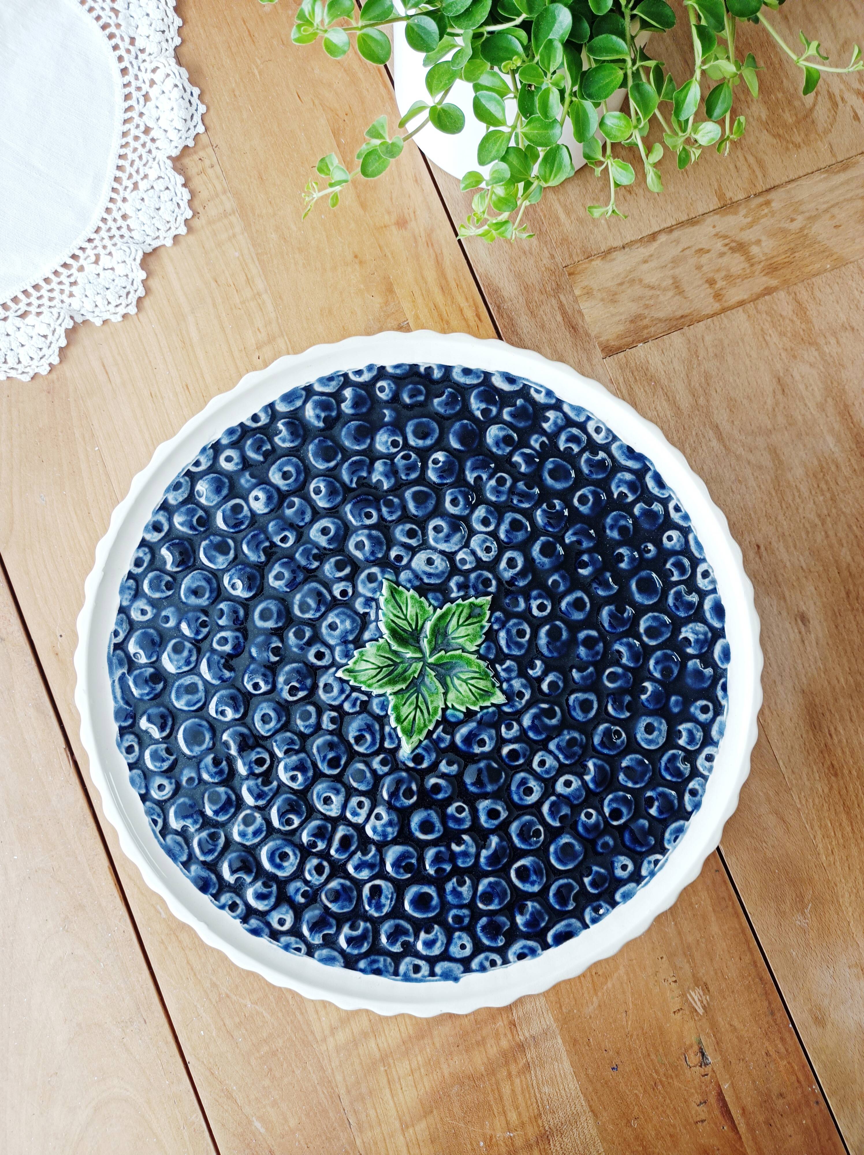 Pie dish on foot, in slip with blackberry decoration