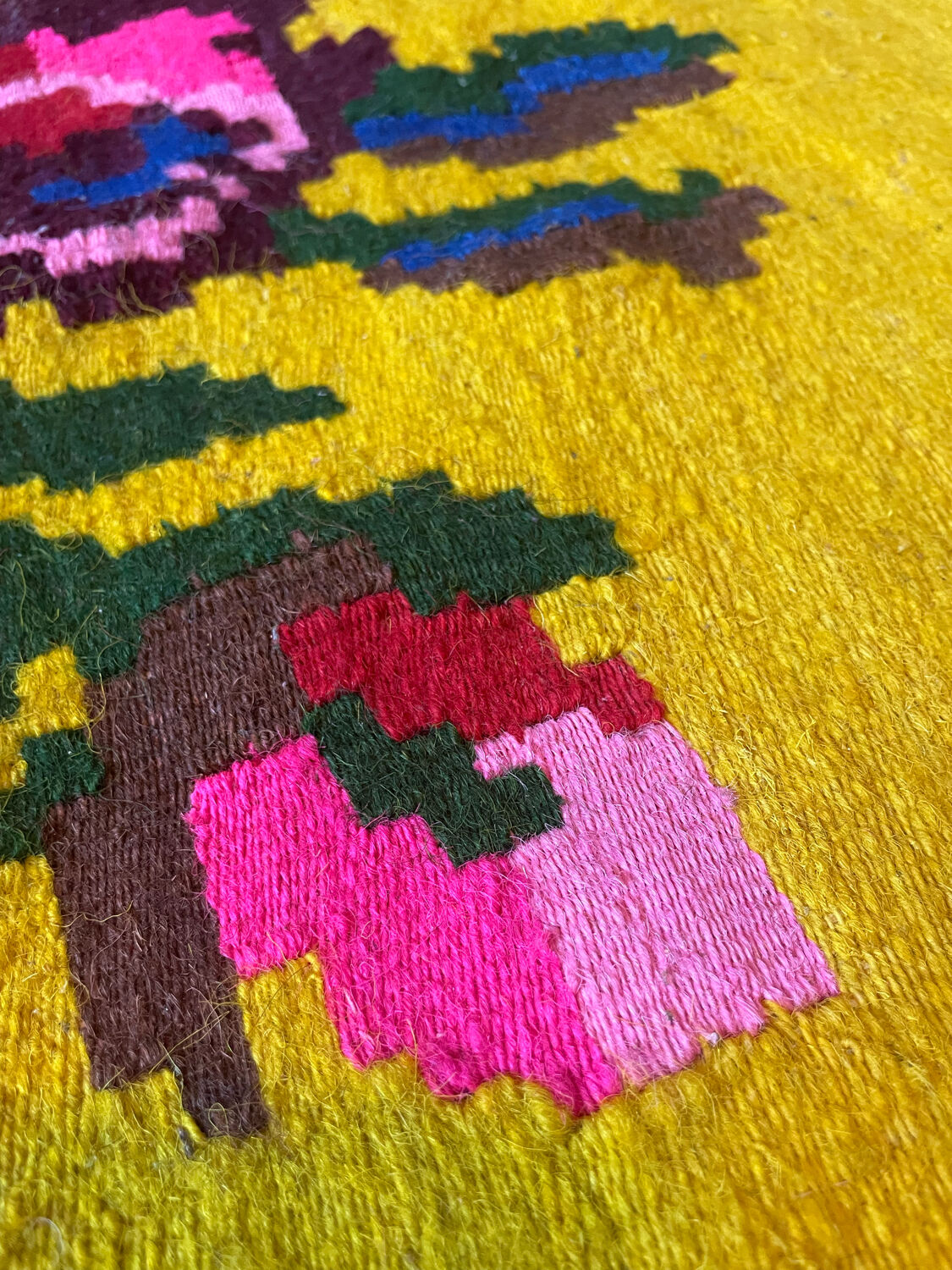 Vintage wool rug with pink flowers on green and yellow background made by hand in Transylvania