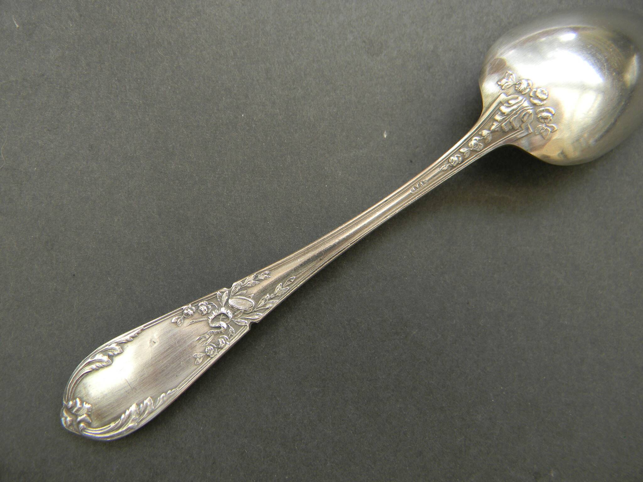 Set of 11 SFAM silver metal teaspoons.