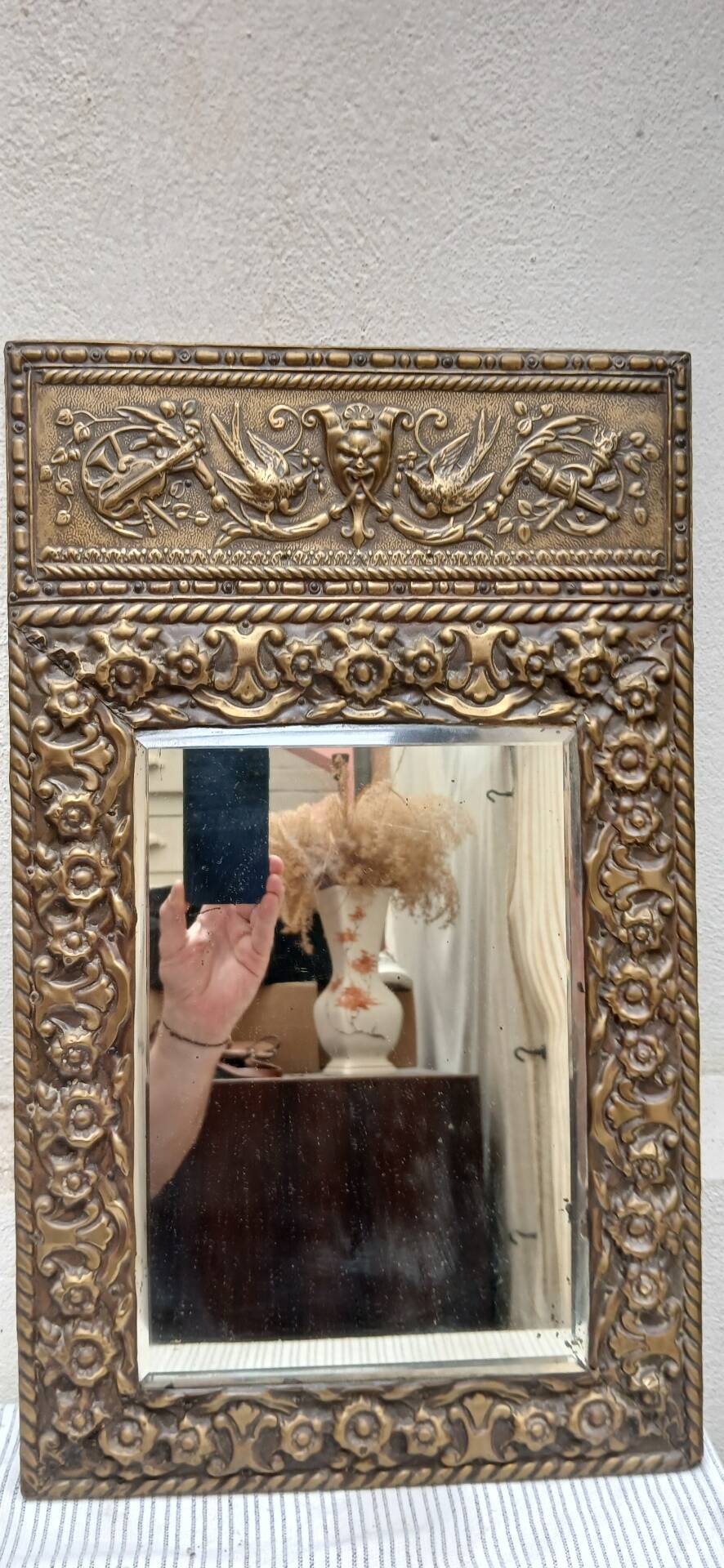 Bevelled mirror from the 1930s in repoussé brass.