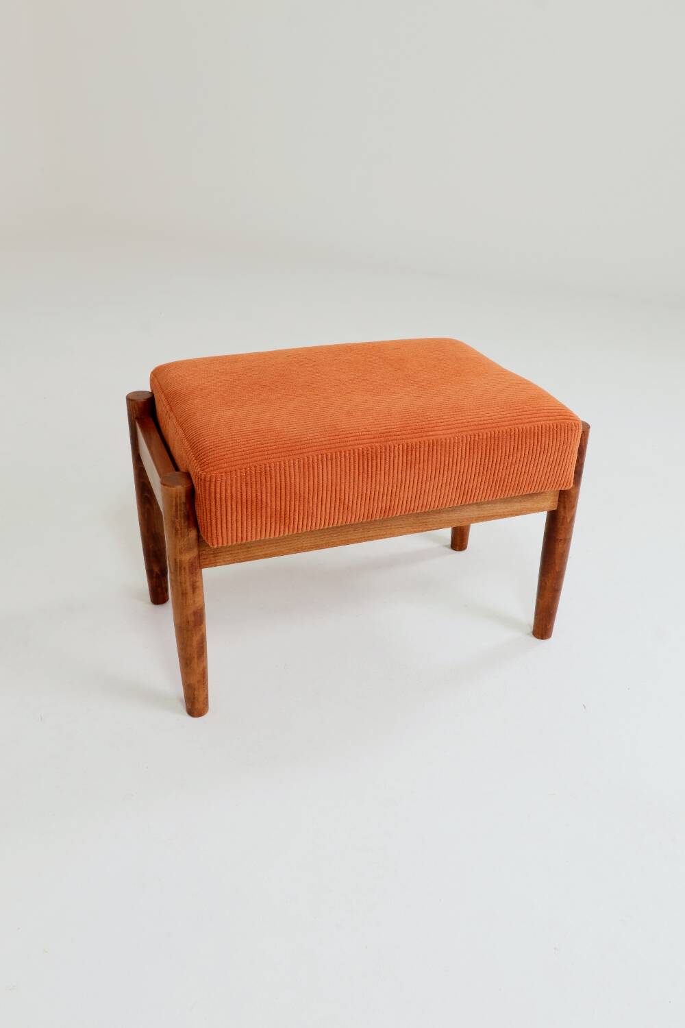 Vintage armchair and footrest in orange corduroy.