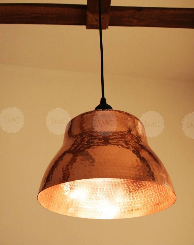 Industrial pendant lamp in the shape of a hammered copper bell.