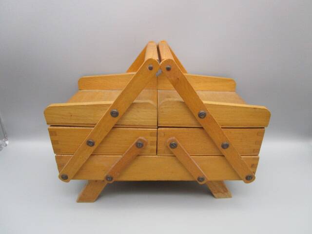 Little worker sewing old wooden table