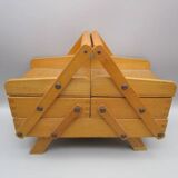 Little worker sewing old wooden table