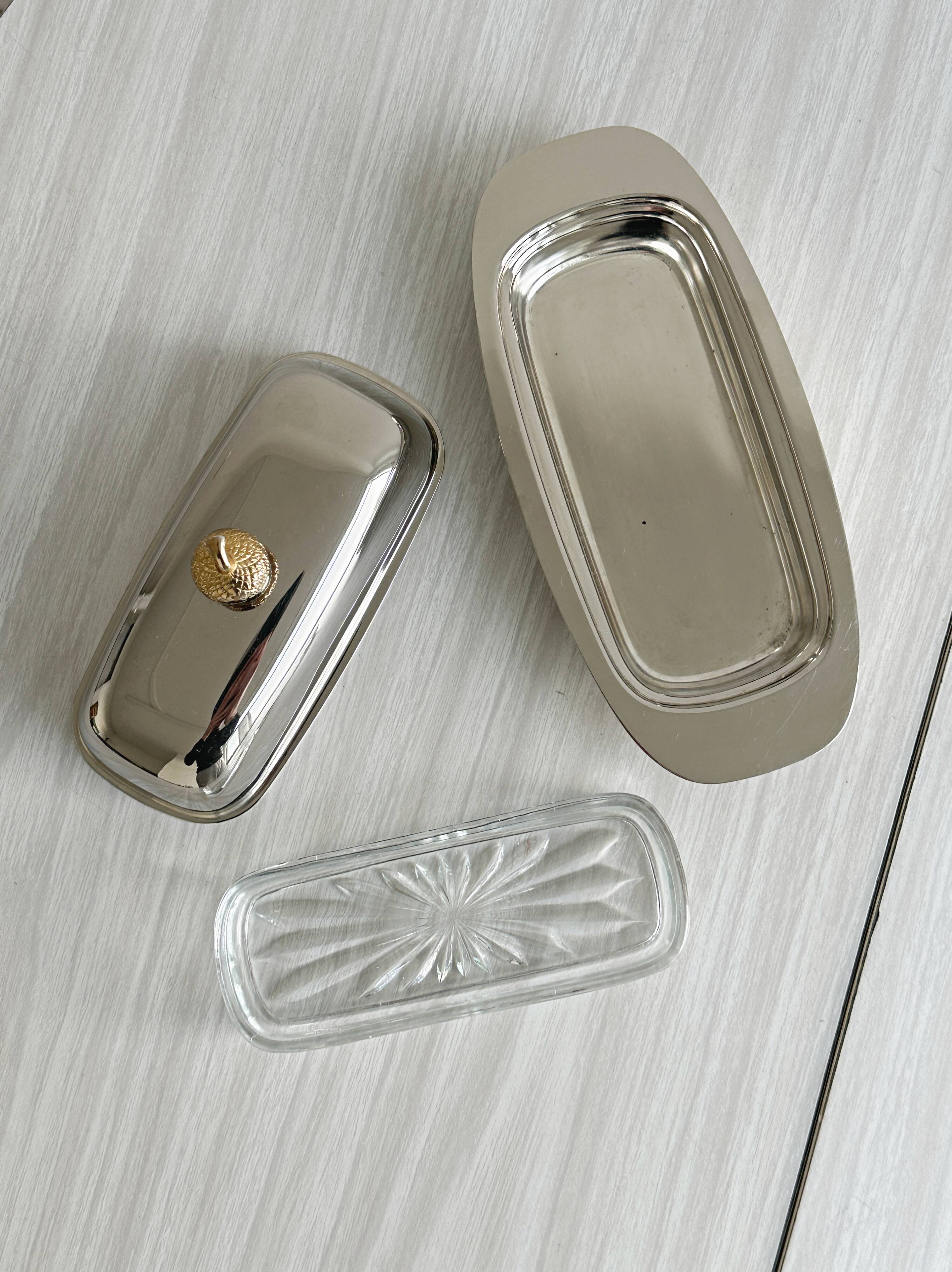 stainless steel butter dish with a golden knob