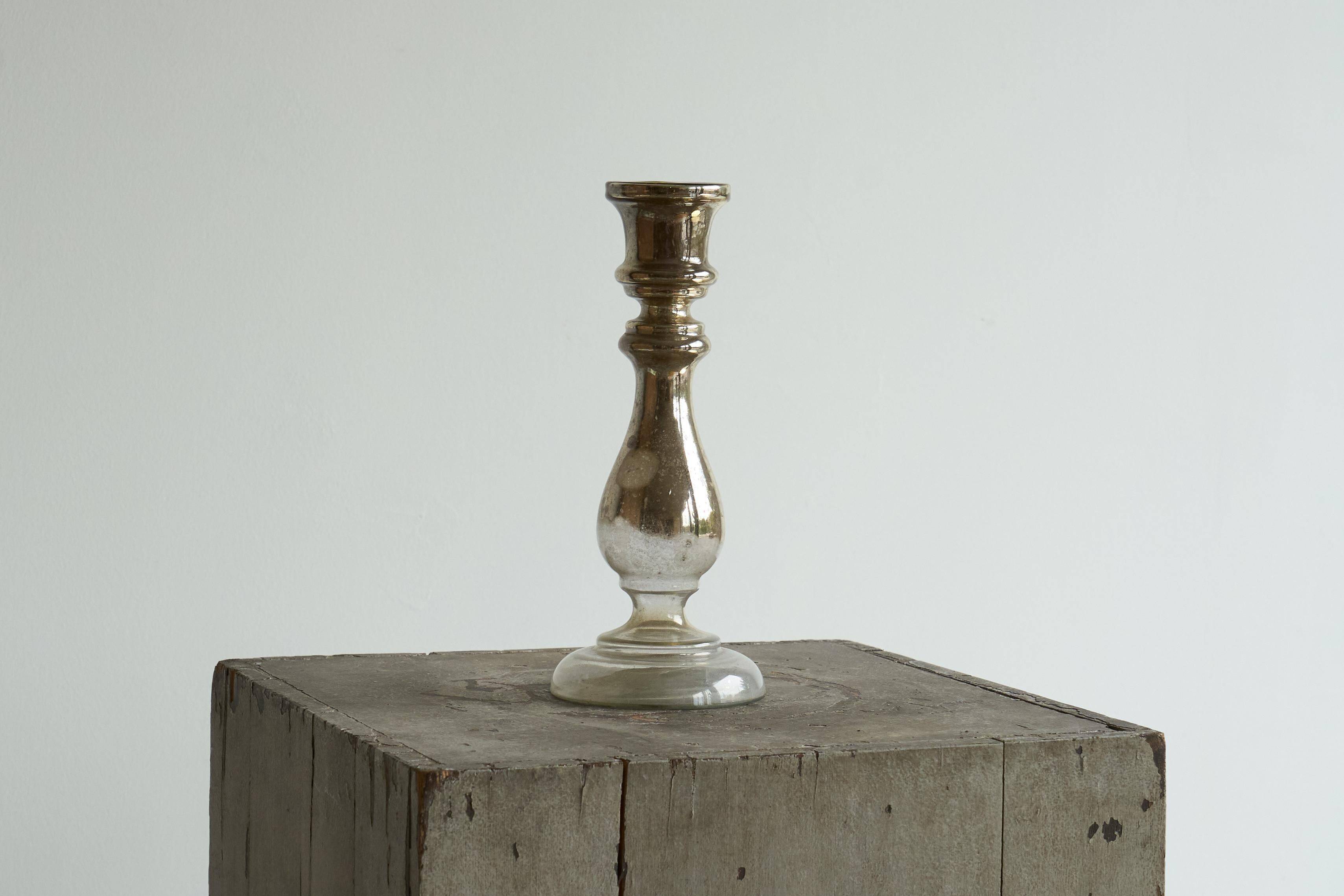 Antique mercury glass candlestick with a patina and silver finish.