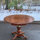 Round dining table, solid wood, central leg, extendable flaps, 20th century.